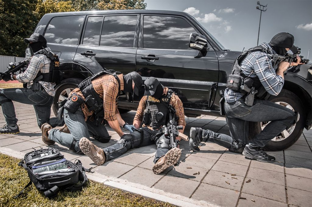 Police operator practicing first aid to injured officer using IFAK